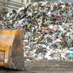 Pile of plastic bottles, paper and polyethylene at a waste recycling plant before sorting.