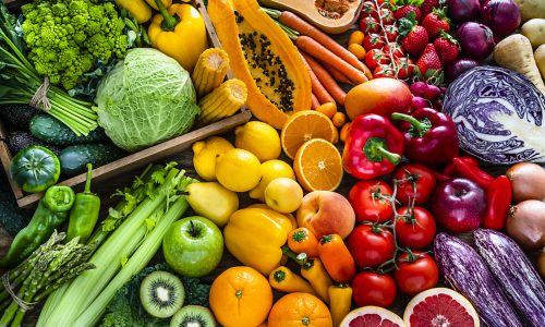 High angle view of a large assortment of healthy fresh rainbow colored organic fruits and vegetables. The composition includes cabbage, carrots, onion, tomatoes, raw potato, avocado, asparagus, eggplant, celery, cucumber, broccoli, squash, lettuce, spinach, lemon, apples, pear, strawberries, papaya, mango, banana, grape fruit, oranges, kiwi fruit among others. The composition is at the left of an horizontal frame leaving useful copy space for text and/or logo at the right. High resolution 42Mp studio digital capture taken with SONY A7rII and Zeiss Batis 40mm F2.0 CF lens